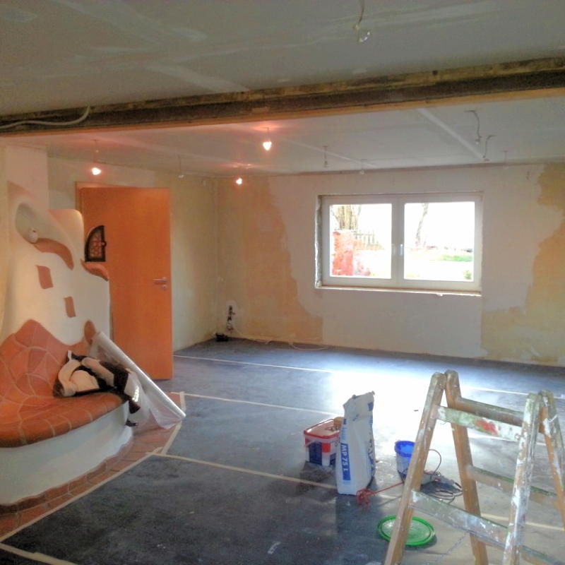 Ein Zimmer wurde für die Malerarbeiten vorbereitet. Die Wände sind von alter Tapete befreit und der Boden ist abgeklebt.
