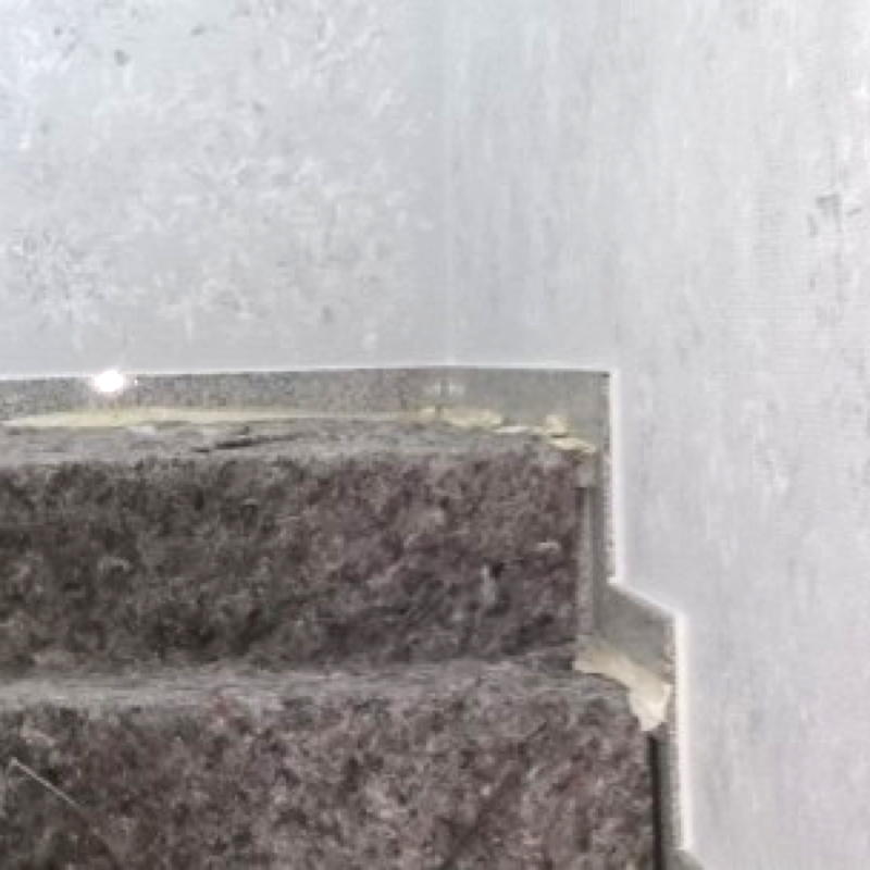 Mit Malerflies abgedeckte Stufen bei einer Treppenhaussanierung.